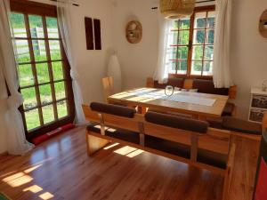 a dining room with a table and chairs and windows at Knusperhaus Ogris in Trieblach