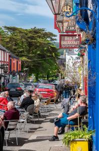 a group of people sitting in chairs on a city street at Foley's Guesthouse & Self Catering Holiday Homes in Kenmare