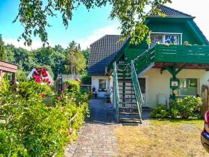 una casa con techo verde y escalera en Am Waldesrand en Prerow