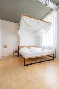 Green Residence Boutique Lofts & Villa في أوفنباخ: غرفة نوم بسرير مع مظلة