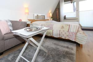 einen kleinen weißen Tisch im Wohnzimmer mit einem Bett in der Unterkunft Am Waldesrand in Prerow