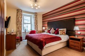 a bedroom with a red and white striped wall at Foley's Guesthouse & Self Catering Holiday Homes in Kenmare