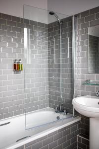 a bathroom with a bath tub and a sink at Burrator Inn in Yelverton