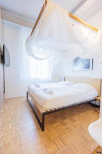 Green Residence Boutique Lofts & Villa في أوفنباخ: غرفة نوم بسرير مع ناموسية