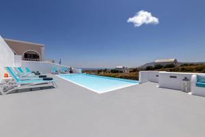 a villa with a swimming pool and chairs at Evas House in Fira