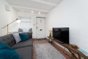 a living room with a couch and a flat screen tv at Tiddles in St Ives
