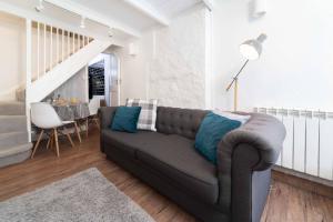 a living room with a couch with blue pillows at Tiddles in St Ives