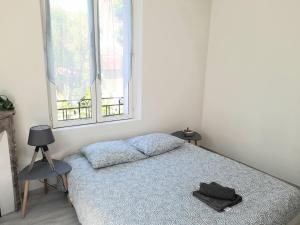 um quarto com uma cama, uma cadeira e uma janela em Le scandinave em Joigny