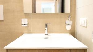 ein Badezimmer mit einem weißen Waschbecken und einem Spiegel in der Unterkunft Casetta La Conchiglia in Villanova di Ostuni