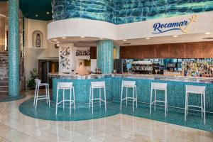 a restaurant with a bar with stools in a lobby at Perla Marina in Nerja