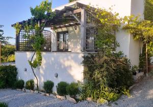 a white house with a pergola and vines at The Gallipoli Houses in Eceabat