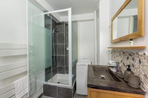 een badkamer met een glazen douche en een wastafel bij Le Flamingo - Premiere conciergerie in Palavas-les-Flots