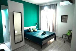 a bedroom with green walls and a bed with a mirror at 4ROOMS b&b - HOLIDAY HOME in Lamezia Terme