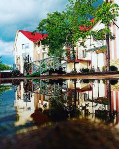 a reflection of a building and a bridge in the water at Pid Yavorom in Ivano-Frankivsʼk