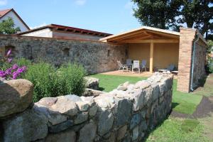 a stone retaining wall in front of a house at Ferienwohnung Am Weltnaturerbe Grumsin in Ziethen
