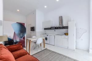 a living room with a couch and a table and a kitchen at Alojamiento con todas las comodidades a pasos de Atocha in Madrid