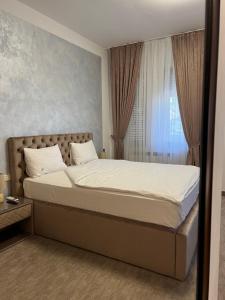 a bedroom with a large bed with a window at Casa Mignon in Oradea