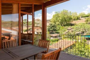 a patio with a wooden table and chairs and a balcony at casa La Vera rural in Talaveruela