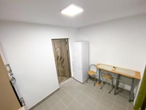 a room with a desk and a table and chairs at Apartament la Malul Dunării in Moldova Veche