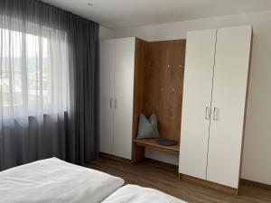 1 dormitorio con 1 cama, armario y ventana en Ferienwohnung Ott, en Ebbs