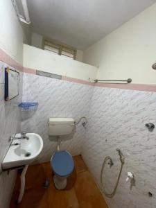 a bathroom with a toilet and a sink at Imperial Inn - HAROZ in Kuttālam