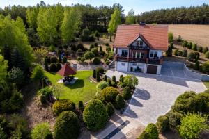 - une vue aérienne sur une maison avec un jardin dans l'établissement Dom na wzgórzu z widokiem na jezioro z balią i sauną, à Lipnica