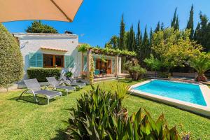 un patio trasero con piscina y sillas y una casa en Can Mir Ruth by Sealand Villas, en Puerto Pollensa