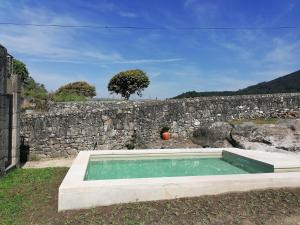 einen Pool vor einer Steinmauer in der Unterkunft Casa do Murungal in Vila Praia de Âncora