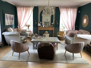 - un salon avec un canapé, une table et des chaises dans l'établissement Domaine "Les Bois Flottes" dans Maison de Charme au bord de mer et proche de Cabourg, à Merville-Franceville-Plage