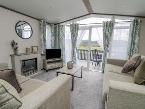 a living room with a couch and a television at Hares Meadow in Caersws