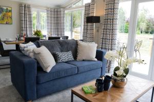 a blue couch in a living room with a table at Hollicarrs - Lilypad Lodge in Riccall