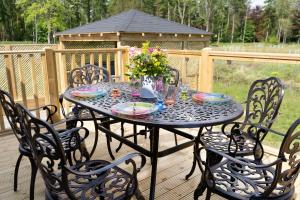 a table with chairs and a vase of flowers on a deck at Hollicarrs - Lilypad Lodge in Riccall