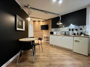 - une cuisine avec une table et des chaises dans la chambre dans l'établissement Petite Viste No. 3 Apartment, à Toruń