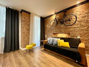 a bike hanging on a brick wall above a couch at Petite Viste No. 3 Apartment in Toruń