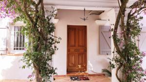 una casa con una porta in legno e fiori di Villa Provençale â Sainte Maxime, Golf de Saint Tropez a Sainte-Maxime Altre 136 foto