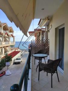 a balcony with a table and chairs and a view of the ocean at Basilis room in Loutsa