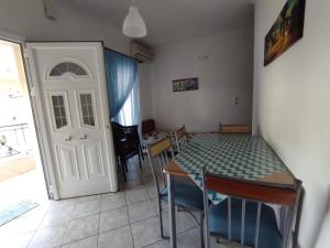 a room with a table and chairs and a white door at Basilis room in Loutsa