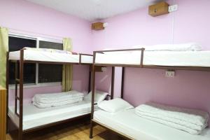 3 letti a castello in una camera con pareti rosa di Margik Backpackers Hostel a Pokhara