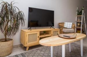 sala de estar con TV y mesa de madera en Villa Nordica - 2 bedroom self-catering apartment, en Ciudad del Cabo