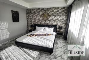 um quarto com uma cama com uma parede de tijolos em Kata Hillside Hotel em Praia de Kata