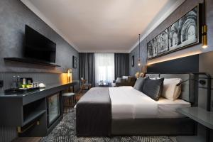 a bedroom with a large bed and a living room at The Wings Hotels Neva Palas in Ankara