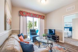 een woonkamer met een bank en een glazen tafel bij Spacious Vista Cay Condo, near Resort Pool in Orlando