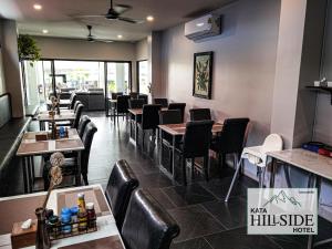 ein Restaurant mit Tischen und Stühlen in einem Raum in der Unterkunft Kata Hillside Hotel in Kata Beach