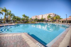 a swimming pool at a resort with palm trees at Gorgeous Top-Floor Condo w Private Balcony in Orlando