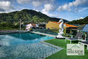 uma piscina com uma estátua ao lado de um edifício em Kata Hillside Hotel em Praia de Kata