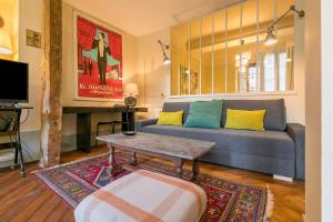 a living room with a couch and a table at Le Saint Michel in Dijon