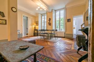 a living room with a wooden floor and a table at Le Saint Michel in Dijon