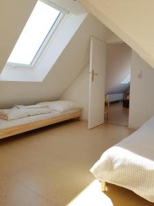 a attic bedroom with a bed and a window at Haus im Felde Whg 5 in Fehmarn