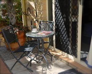 a table and two chairs on a porch at Beachhouse Bed and Breakfast in Redcliffe