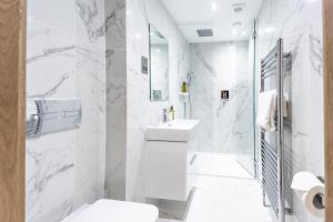 Baño blanco con aseo y lavamanos en No1 Apartments St Andrews - South Street en St Andrews